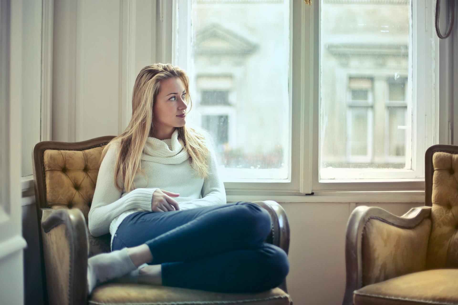 Femme pensive assise dans un fauteuil