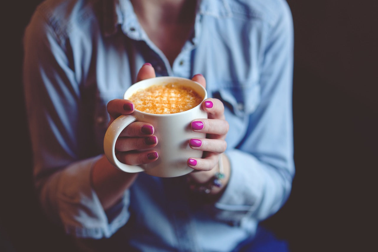 Femme tenant un café dans ses mains